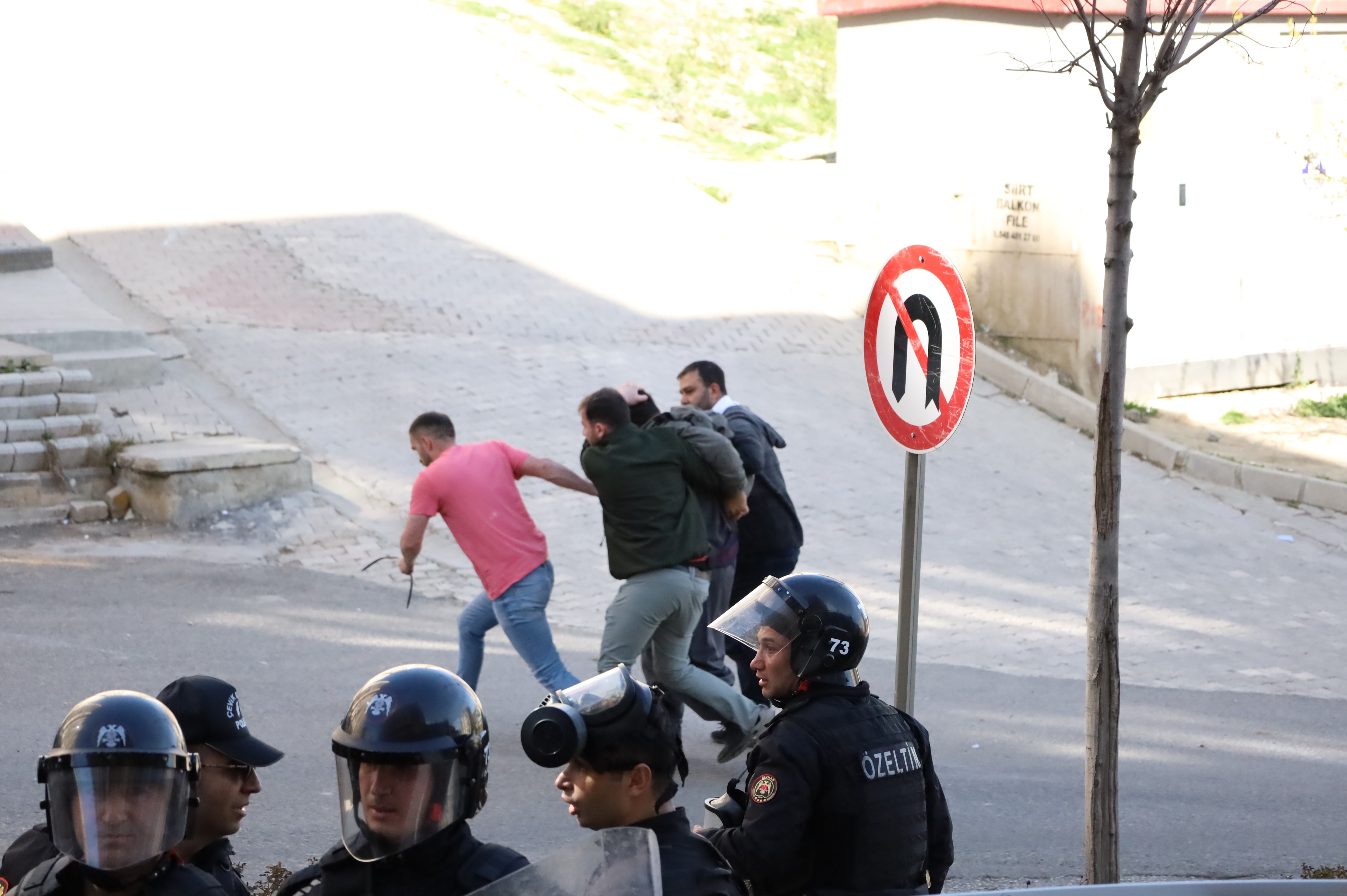 polisler bir kişiyi gözaltına alıyor