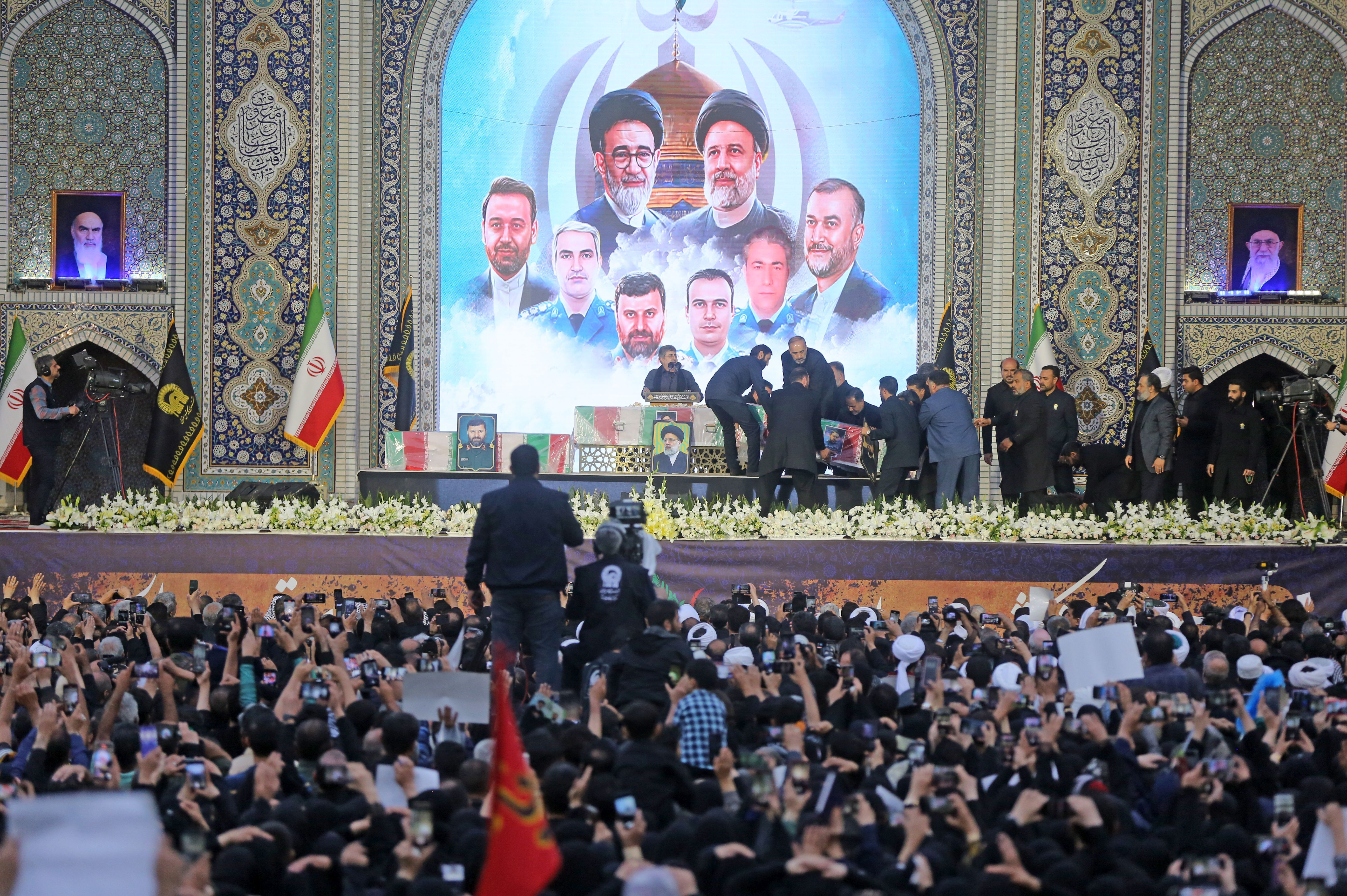 siyah giyinen kalabalık, İbrahim Reisi'nin fotoğrafı