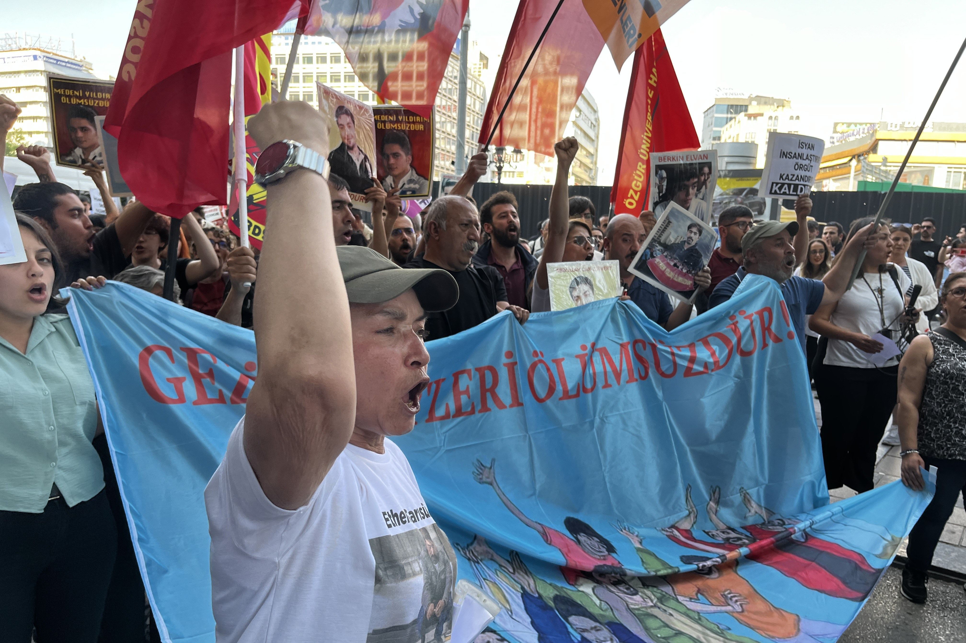 ellerini yumruk yaparak havaya kaldıran kalabalık, pankart, bayrak