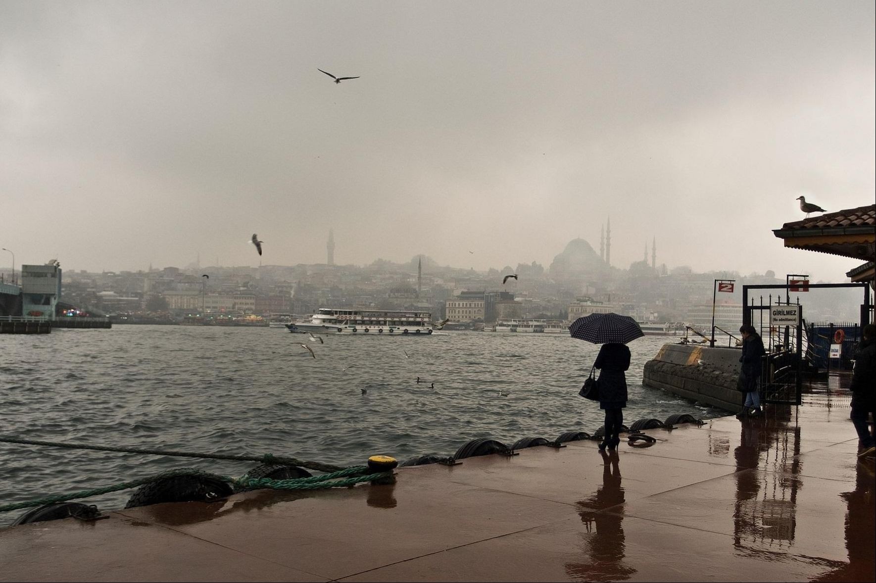 İstanbul'da sağanak yağışta iskelede insanlar