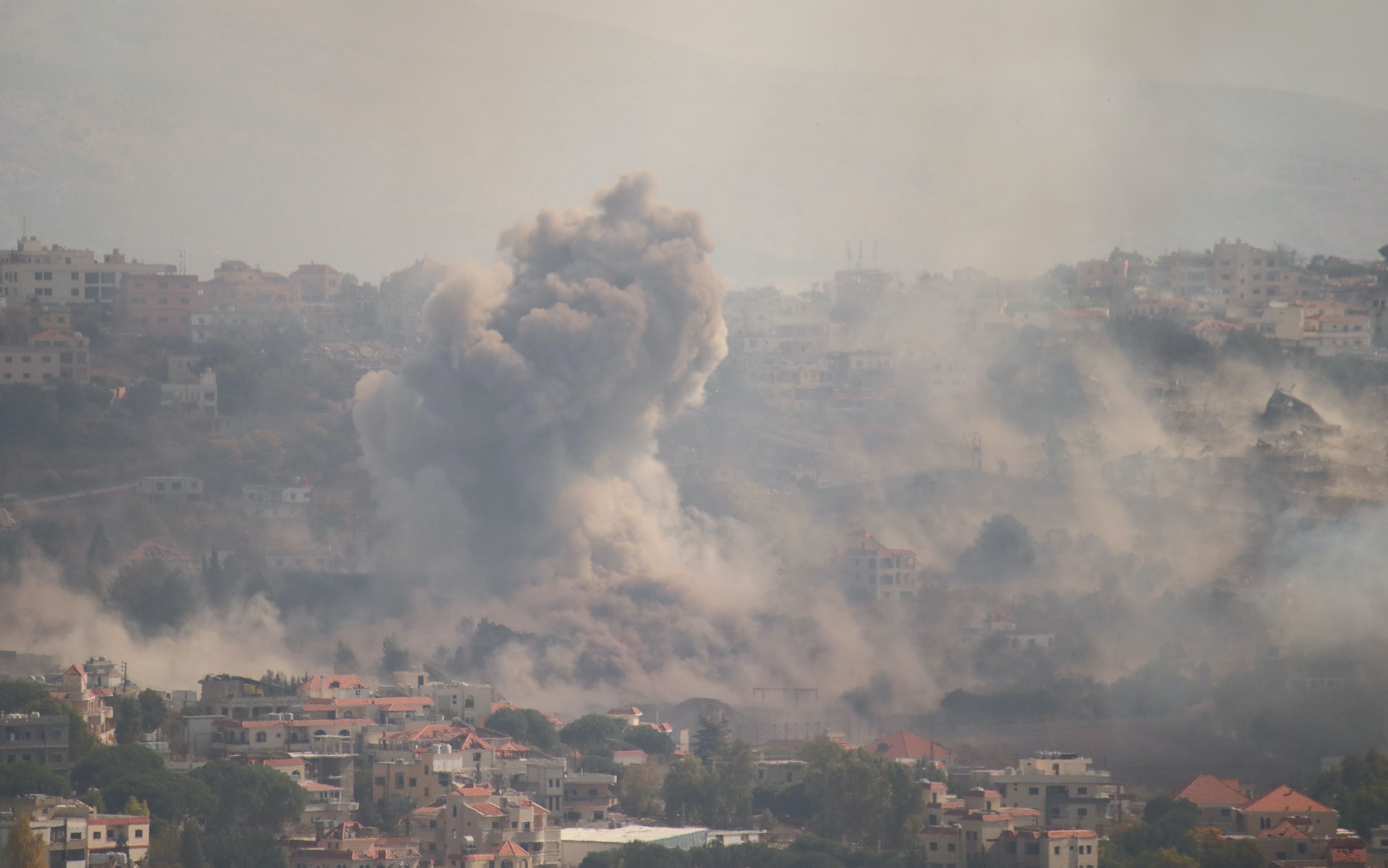 kentin uzaktan görünümü, bombardıman sonrası yükselen toz bulutu