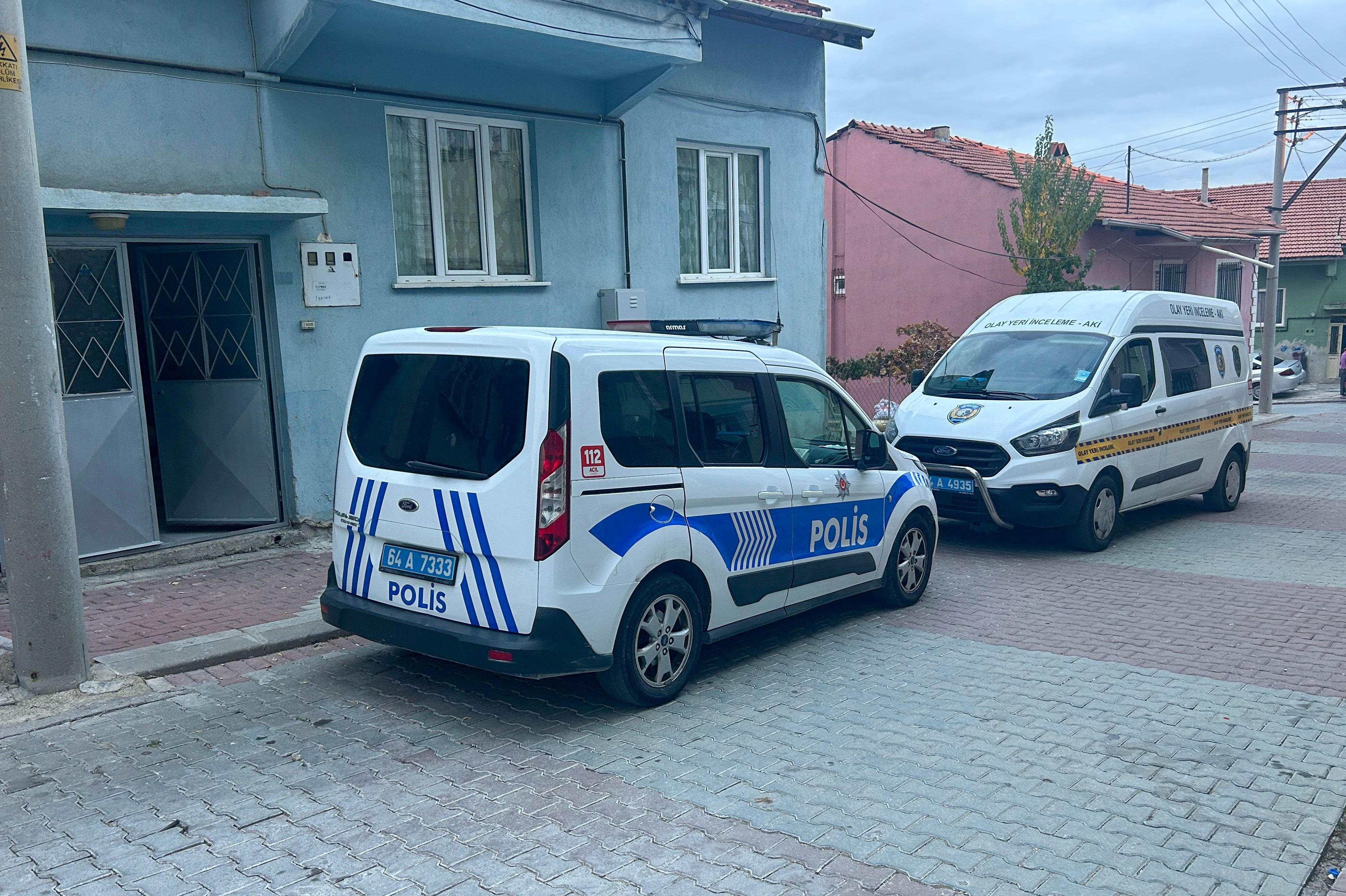 Kapı önündeki polis ve olay yeri inceleme aracı