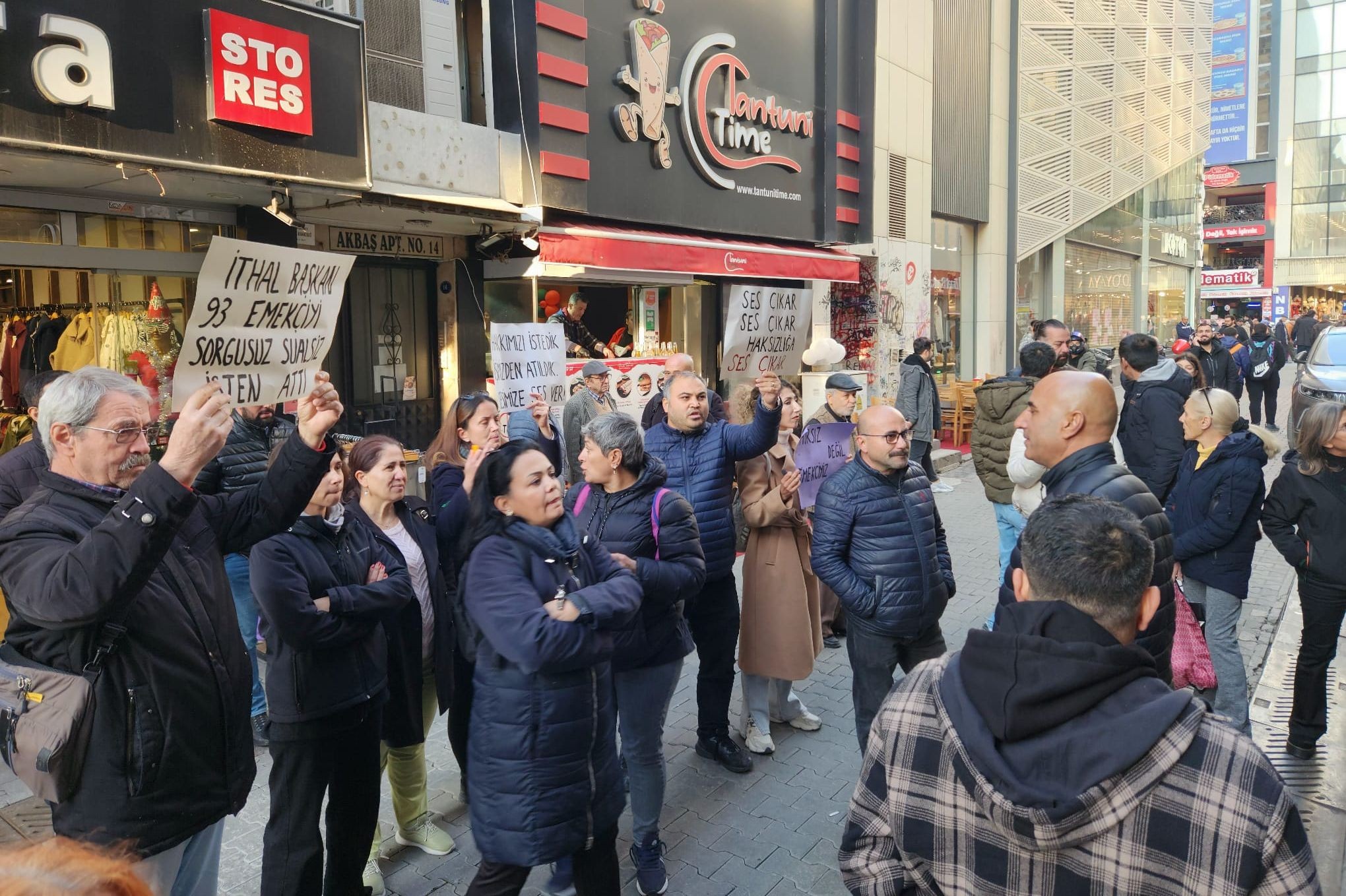 ellerinde sloganların yazılı olduğu kartonları tutan bir grup kalabalık